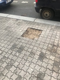 Rozbitý chodník v ulici Italská, před domem číslo 32