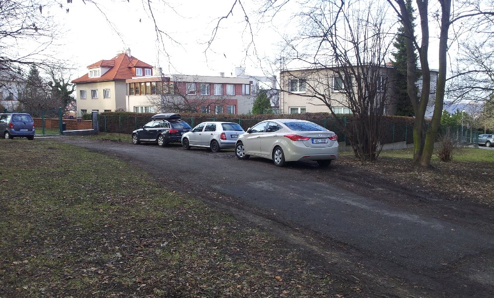 Parkování aut v zeleni v ulici Pod kostelem, Praha 6 