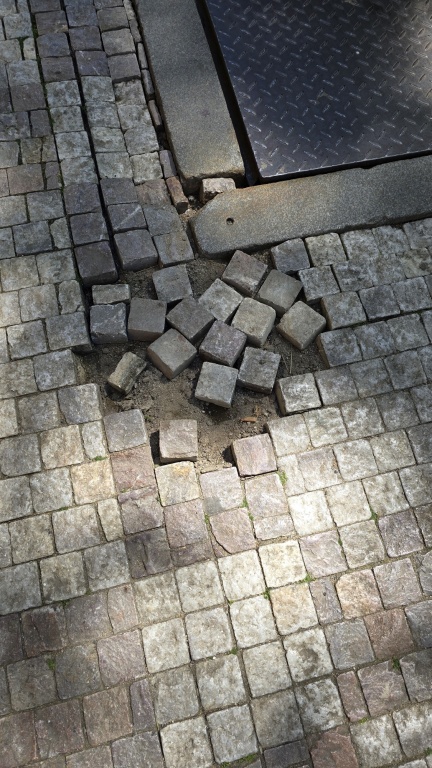 Poškozený chodník - vypadané dlažební kostky